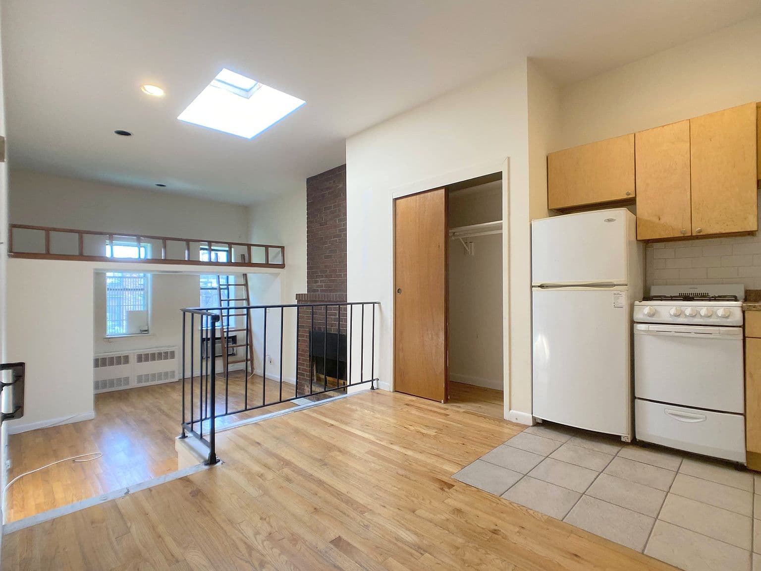 Prewar-Inspired Studio with Decorative Fireplace and Raised Dining Area