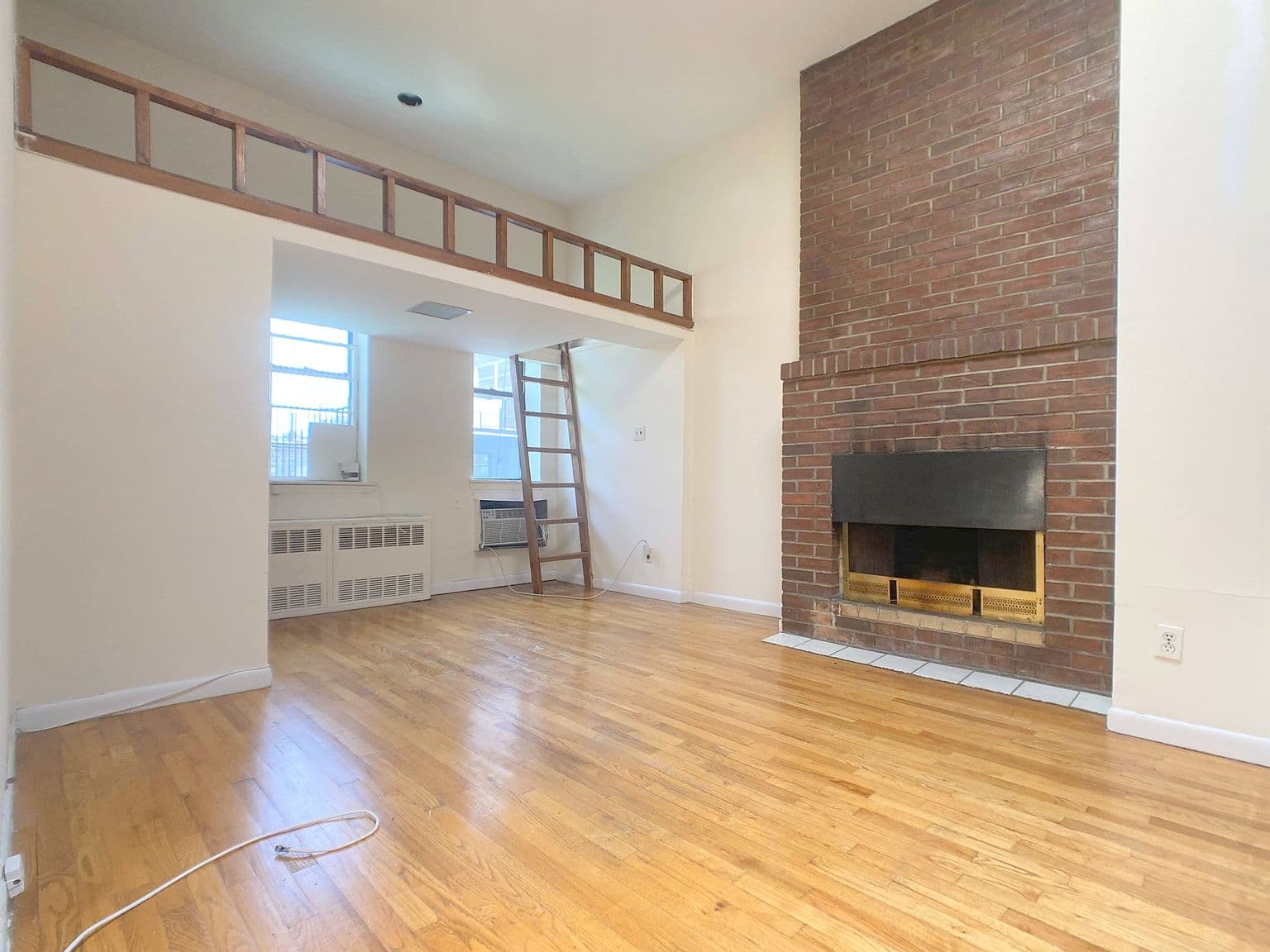 Prewar-Inspired Studio with Decorative Fireplace and Raised Dining Area